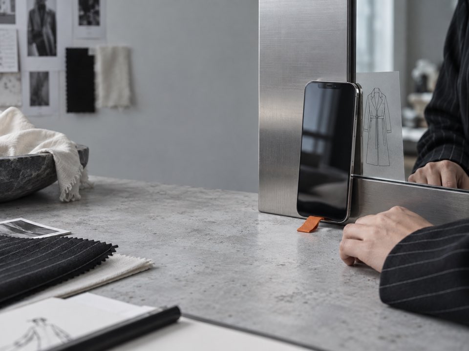 A phone, product sketch, and materials in a studio